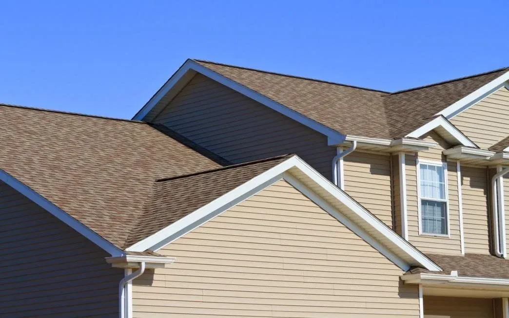 Affordable Siding, Windows & Roofing tan vinyl siding under layered gable roofs